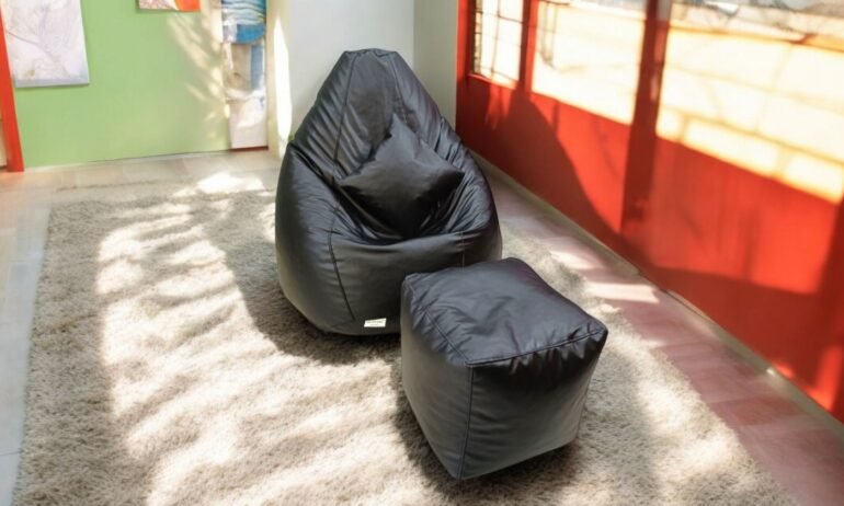 Black leatherette bean bag with footrest and cushion on a soft carpet – perfect seating for homes in Pune, Bengaluru, Hyderabad, and across India.